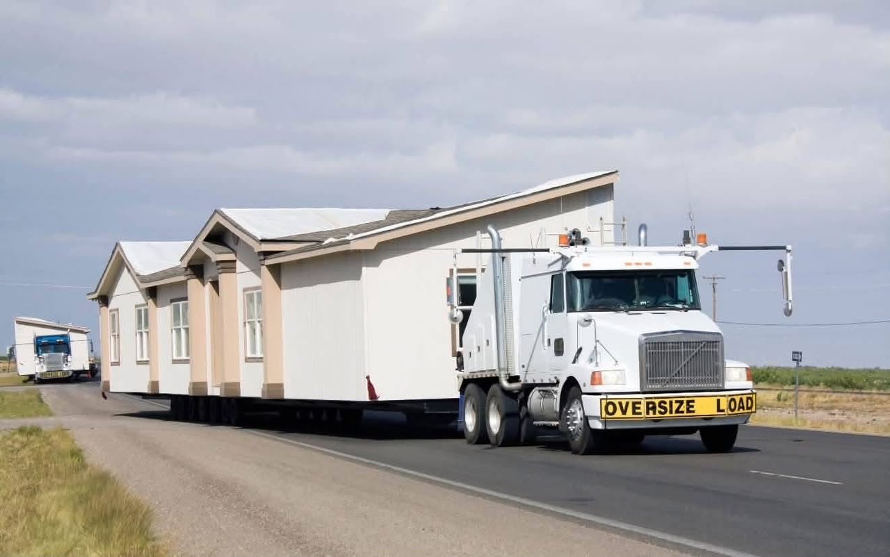 Mobile home escort vehicle during highway transport